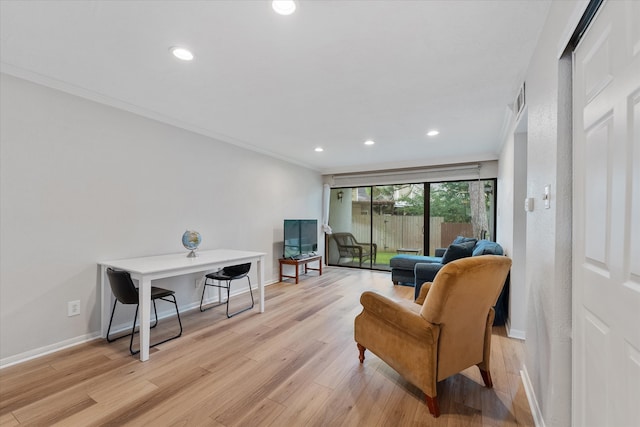 living area featuring light hardwood / wood-style flooring and ornamental molding