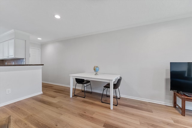 dining room featuring ornamental molding and light hardwood / wood-style flooring