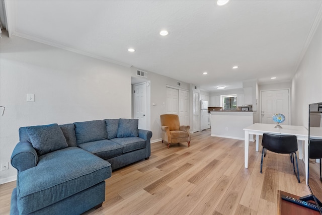 living room featuring light hardwood / wood-style flooring and ornamental molding