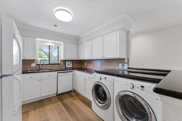 laundry area with light wood-type flooring, separate washer and dryer, sink, and crown molding