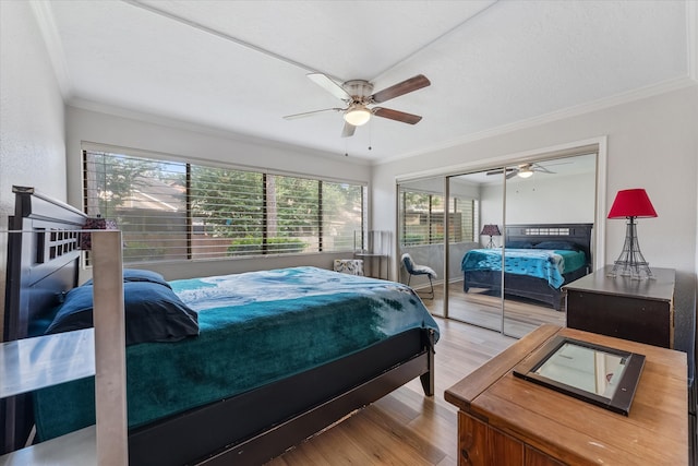 bedroom with ceiling fan, a closet, crown molding, and wood-type flooring