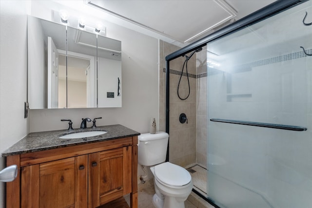 bathroom with toilet, vanity, and a shower with door