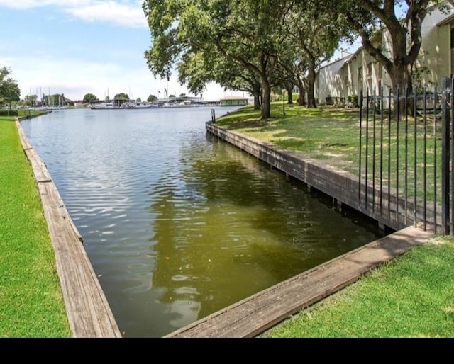 dock area featuring a water view and a yard