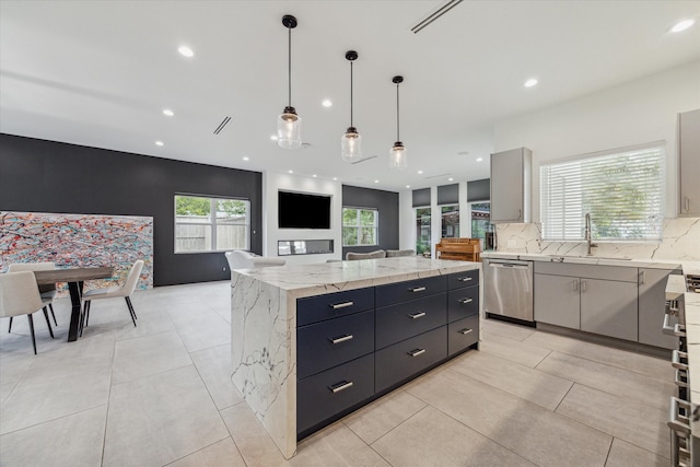 kitchen with a spacious island, pendant lighting, dishwasher, tasteful backsplash, and sink