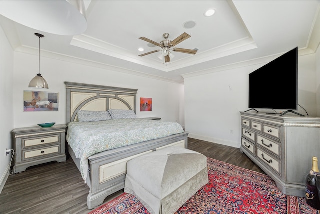 bedroom featuring a tray ceiling, ornamental molding, ceiling fan, and dark hardwood / wood-style floors