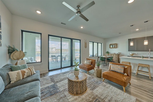 living room featuring ceiling fan and light hardwood / wood-style floors