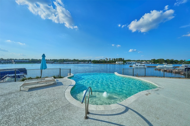 view of swimming pool featuring a water view and a patio area