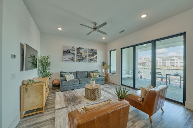 living room with ceiling fan and light hardwood / wood-style floors