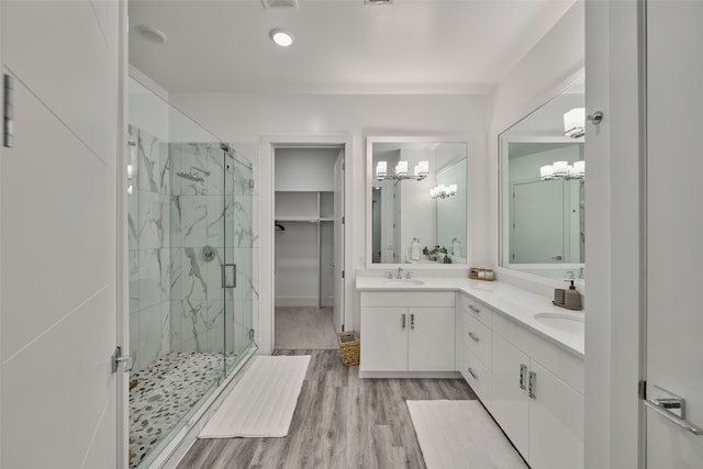 bathroom featuring hardwood / wood-style floors, a shower with shower door, a chandelier, and vanity