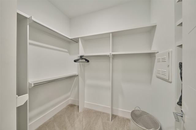 walk in closet featuring light colored carpet