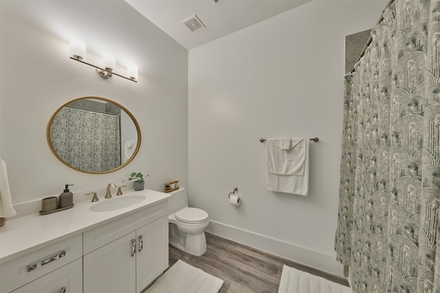 bathroom featuring curtained shower, hardwood / wood-style floors, toilet, and vanity