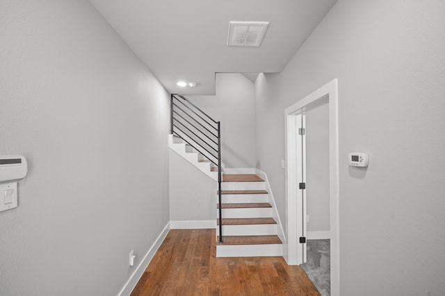 staircase with hardwood / wood-style floors