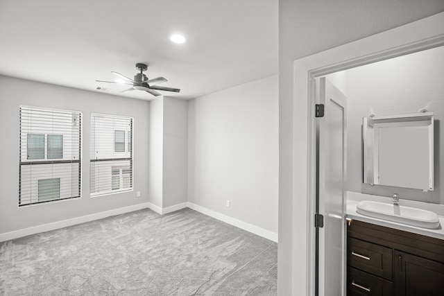 unfurnished room featuring ceiling fan, light colored carpet, and sink