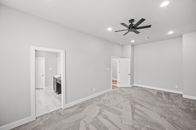 carpeted empty room with ceiling fan and a fireplace