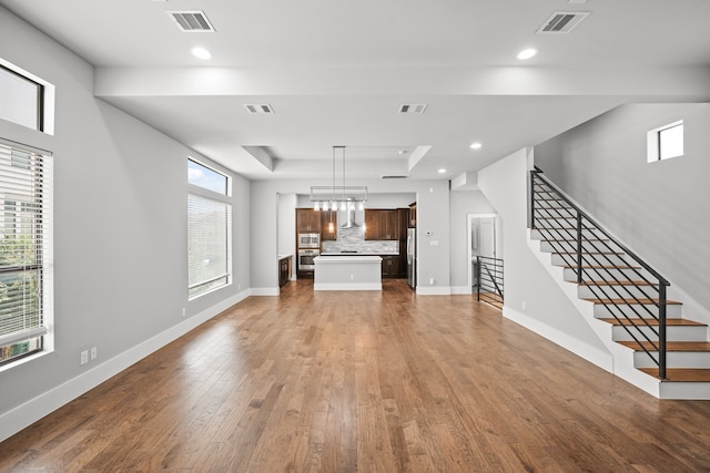 unfurnished living room featuring a wealth of natural light and dark wood-type flooring