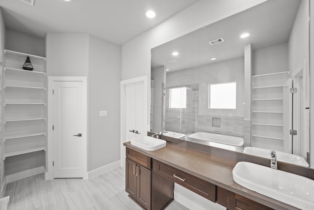 bathroom featuring vanity, hardwood / wood-style flooring, and tiled shower