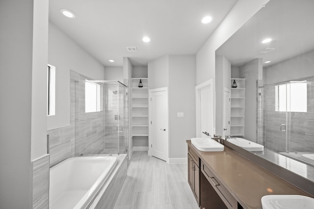 bathroom featuring vanity, shower with separate bathtub, and hardwood / wood-style floors