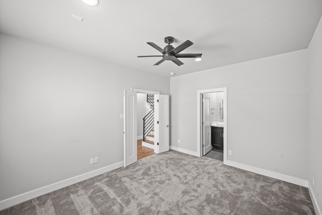 unfurnished bedroom with connected bathroom, ceiling fan, and light colored carpet