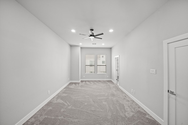 spare room with ceiling fan and light colored carpet