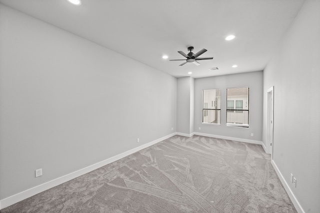 carpeted spare room featuring ceiling fan