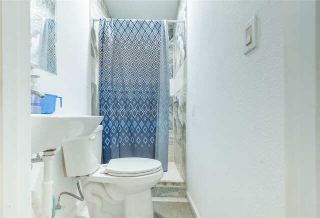 bathroom with a shower with shower curtain and toilet