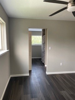 empty room featuring dark wood-type flooring and ceiling fan