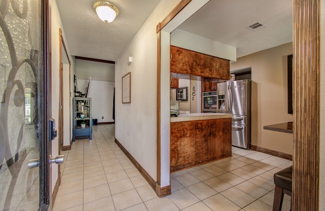 interior space featuring a textured ceiling and light tile patterned floors