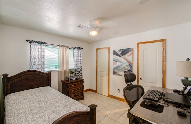 tiled bedroom featuring ceiling fan and a textured ceiling