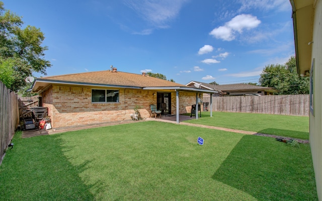 back of house with a patio area and a yard