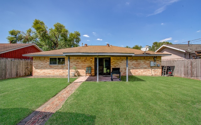 rear view of property featuring a yard and a patio area