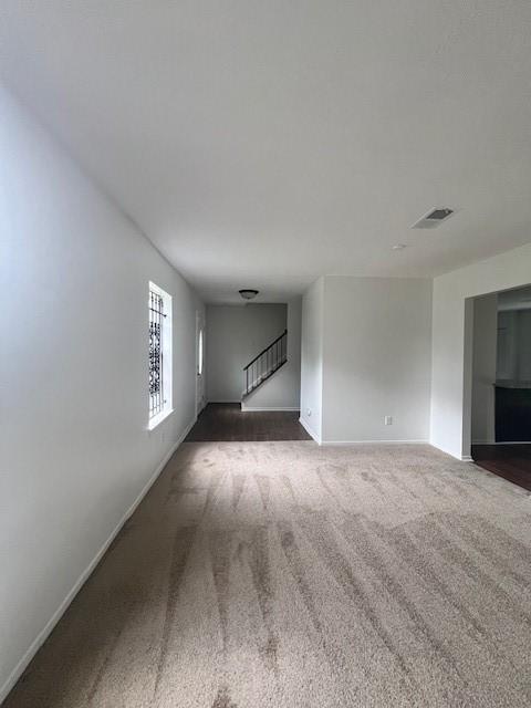 unfurnished living room featuring dark carpet