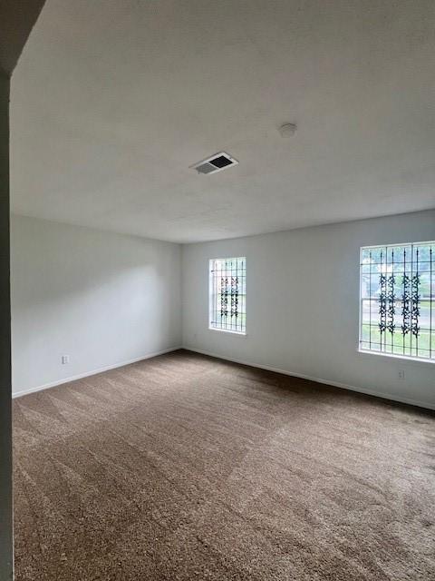 spare room featuring carpet flooring and a textured ceiling