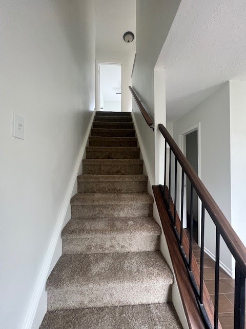 stairs with a textured ceiling