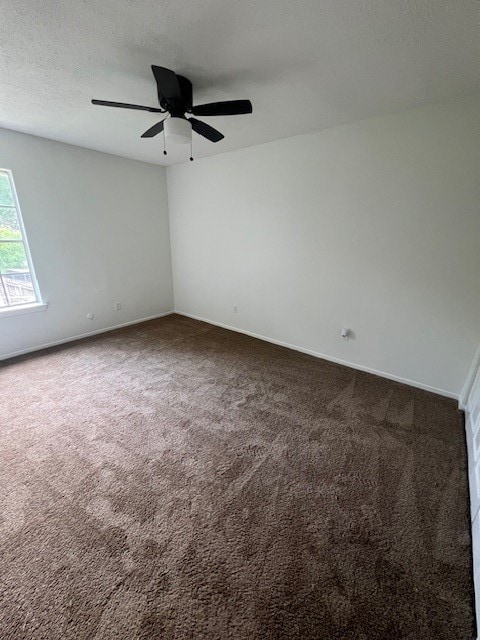 spare room featuring a textured ceiling, carpet flooring, and ceiling fan