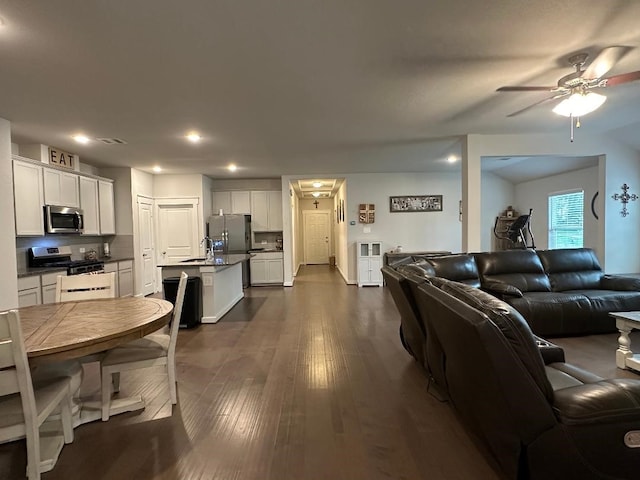 living room featuring ceiling fan, dark hardwood / wood-style floors, and sink