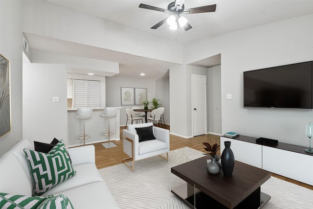 living room featuring hardwood / wood-style floors and ceiling fan