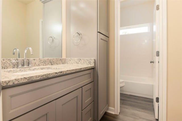 bathroom with hardwood / wood-style floors, toilet, and vanity