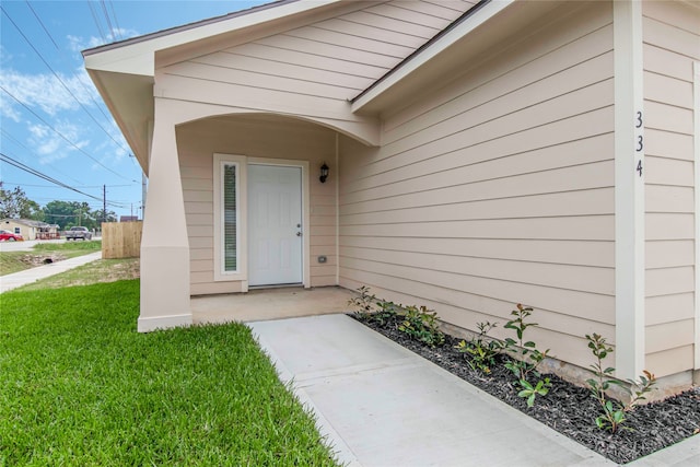 property entrance featuring a lawn