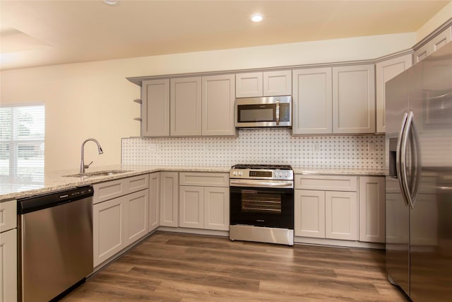 kitchen featuring dark wood-type flooring, tasteful backsplash, stainless steel appliances, and sink