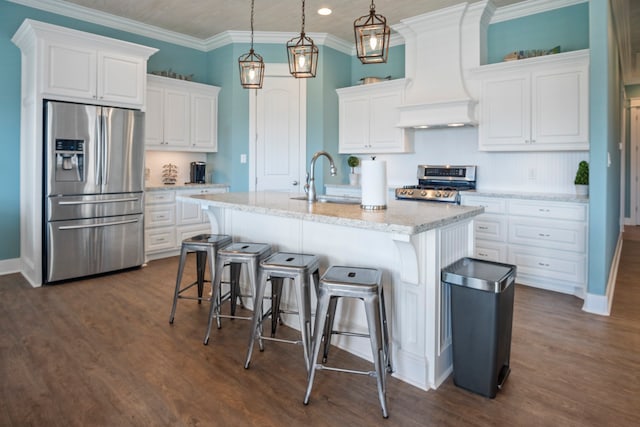 kitchen with white cabinets, an island with sink, appliances with stainless steel finishes, and hanging light fixtures