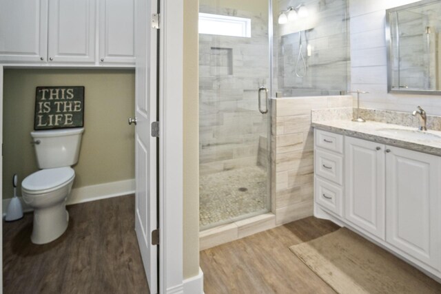 bathroom featuring walk in shower, vanity, hardwood / wood-style floors, and toilet