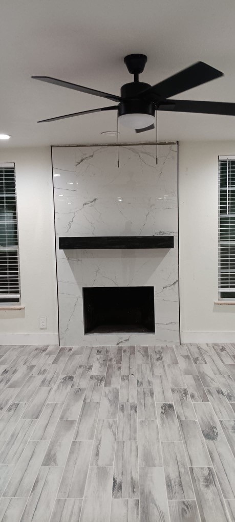 room details with a fireplace, wood-type flooring, and ceiling fan