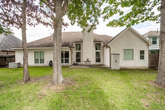 rear view of house with a yard, a patio, and central air condition unit