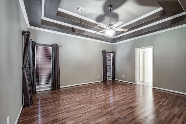 spare room with a raised ceiling, crown molding, dark hardwood / wood-style flooring, and ceiling fan