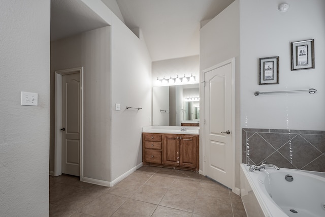 bathroom featuring tiled tub, tile patterned flooring, and vanity