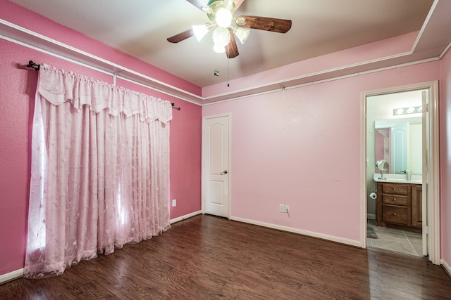 unfurnished bedroom featuring connected bathroom, ceiling fan, and dark hardwood / wood-style flooring