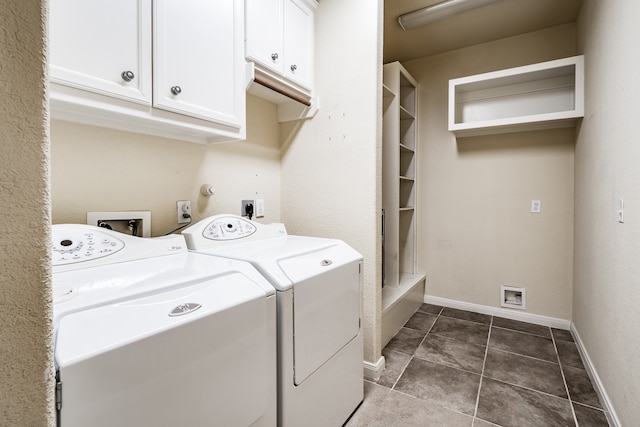 laundry room featuring dark tile patterned flooring, washer and dryer, and cabinets