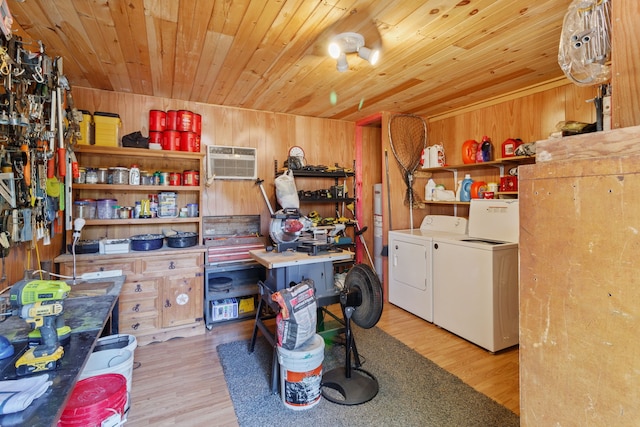 interior space featuring light wood-type flooring, wood ceiling, wooden walls, and washing machine and clothes dryer