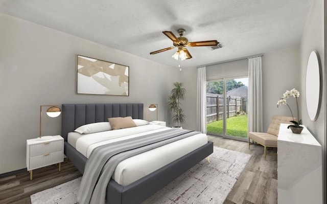 bedroom with ceiling fan, hardwood / wood-style flooring, access to exterior, and a textured ceiling