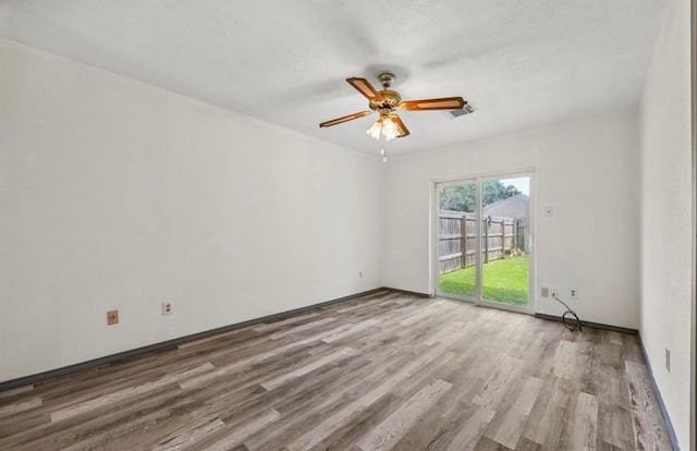 empty room with a textured ceiling, light hardwood / wood-style floors, and ceiling fan